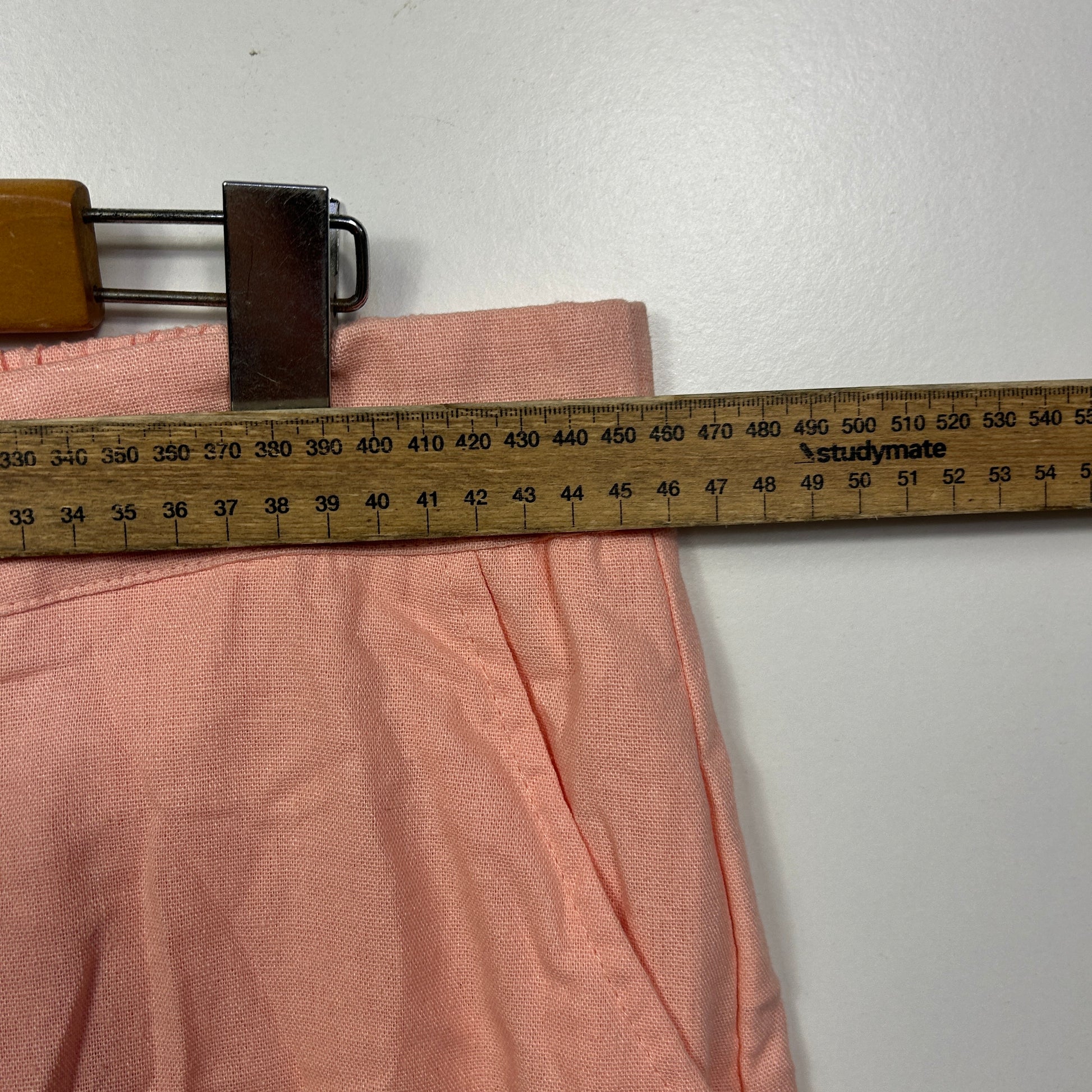 Pink fabric measured on tape measure detail view