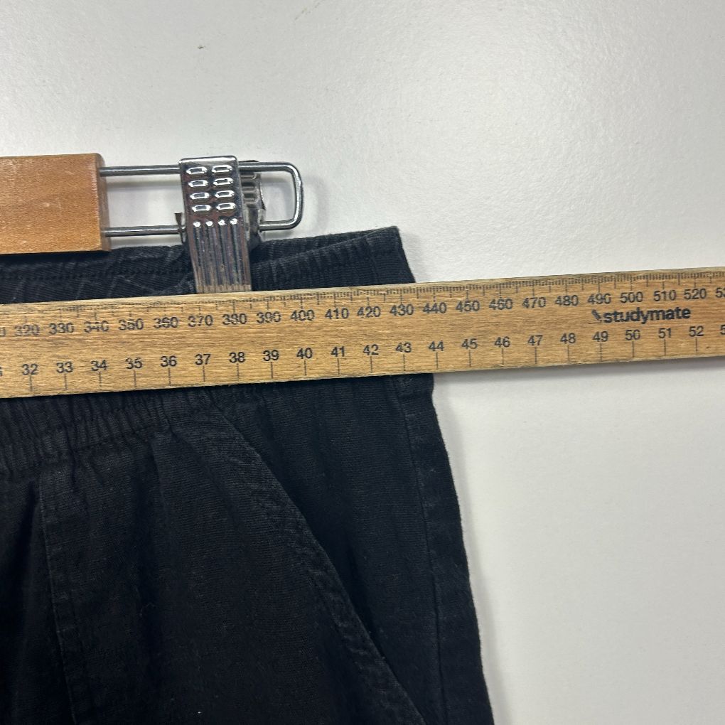 Black trousers waistband detail with measuring tape