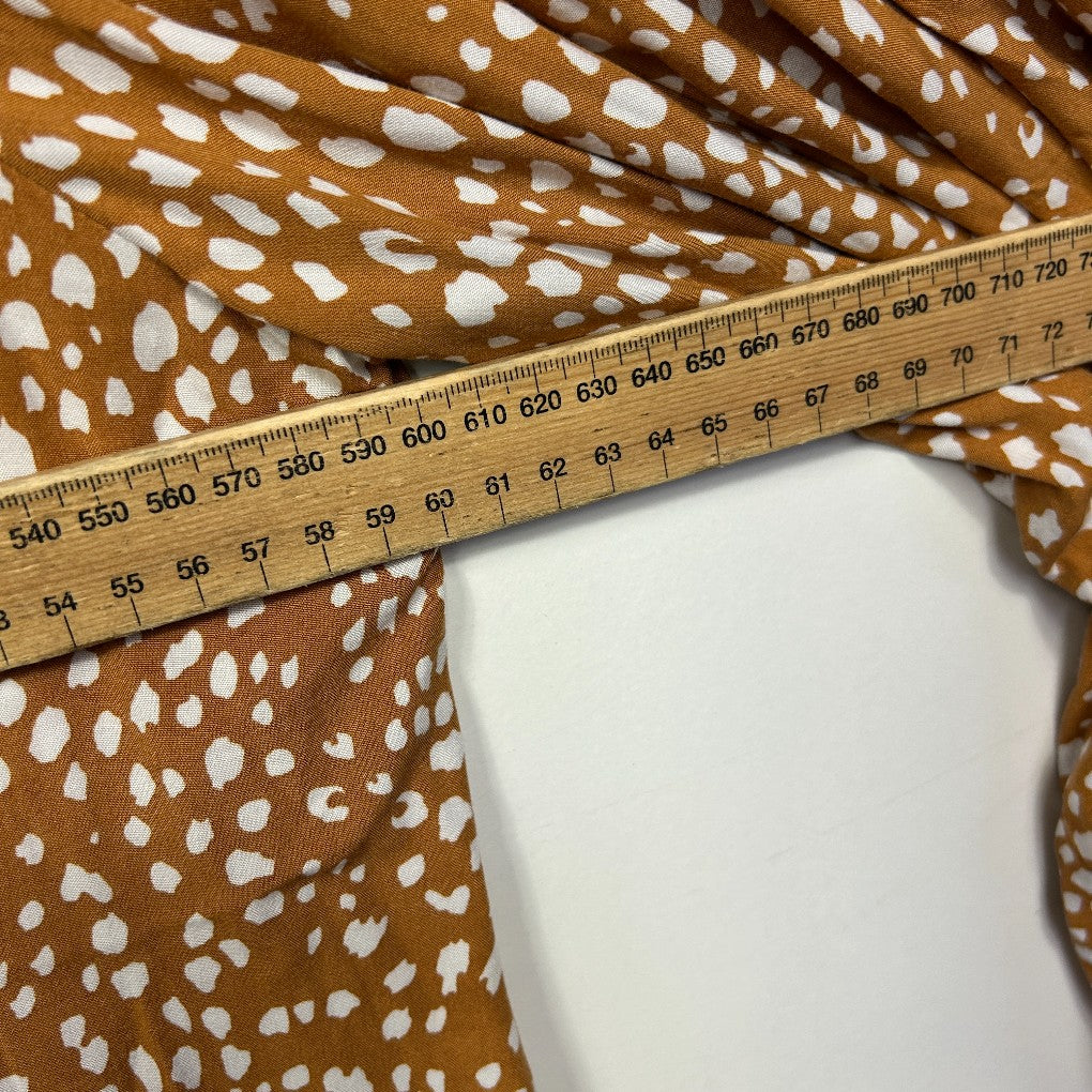 Brown and white spotted fabric detail view with measuring tape