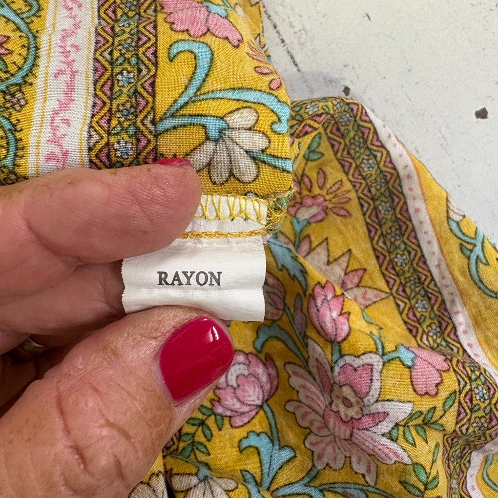 Yellow floral fabric detail view with rayon label