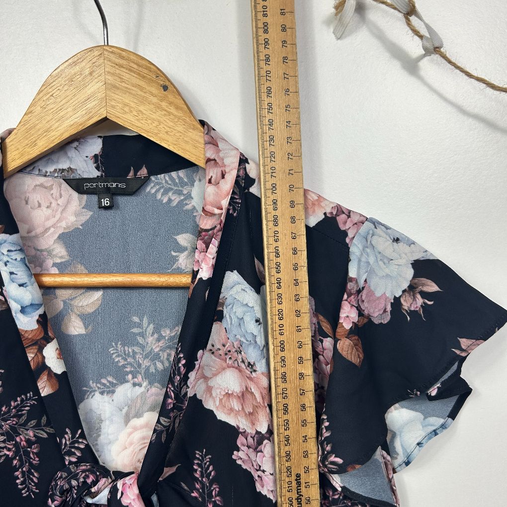 Black floral blouse front view on wooden hanger