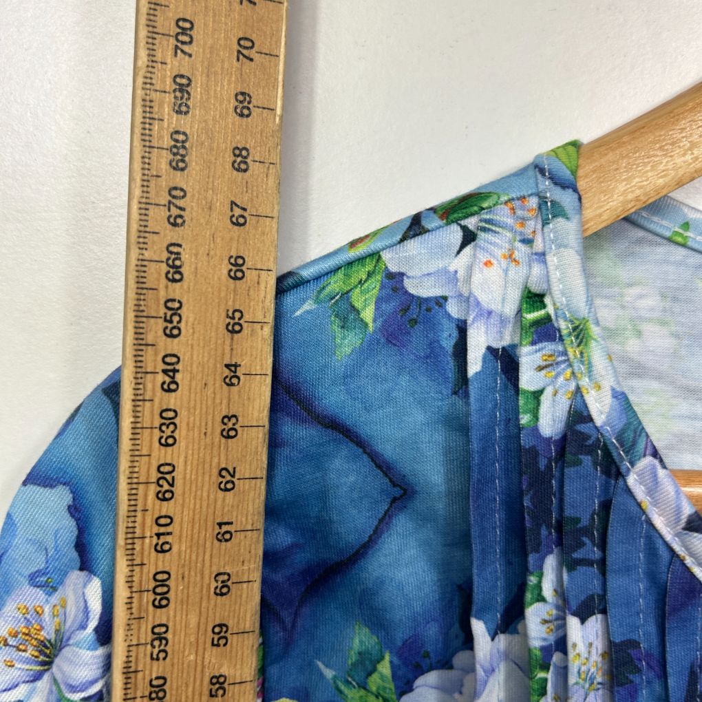 Blue floral dress detail view with measuring tape