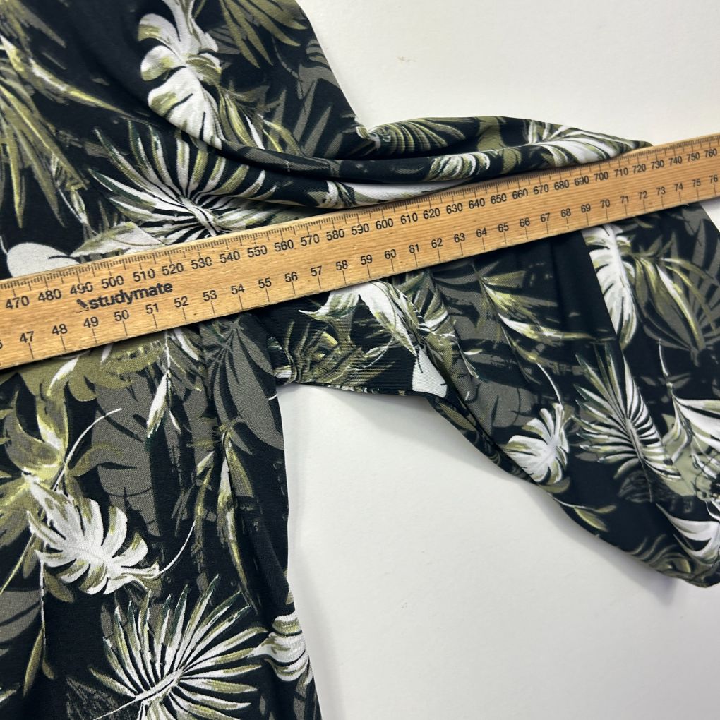 Black floral print shirt detail view with measuring tape