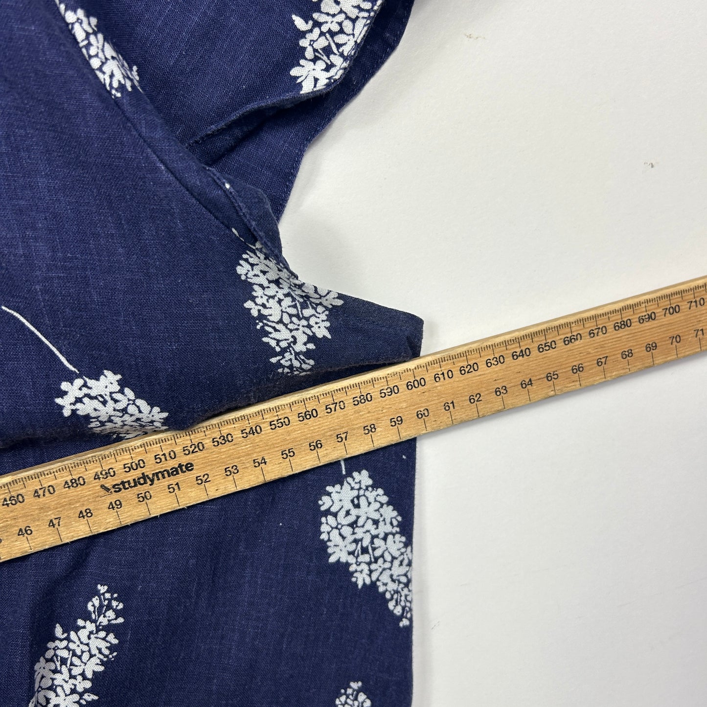 Navy fabric with white floral pattern detail view with measuring tape