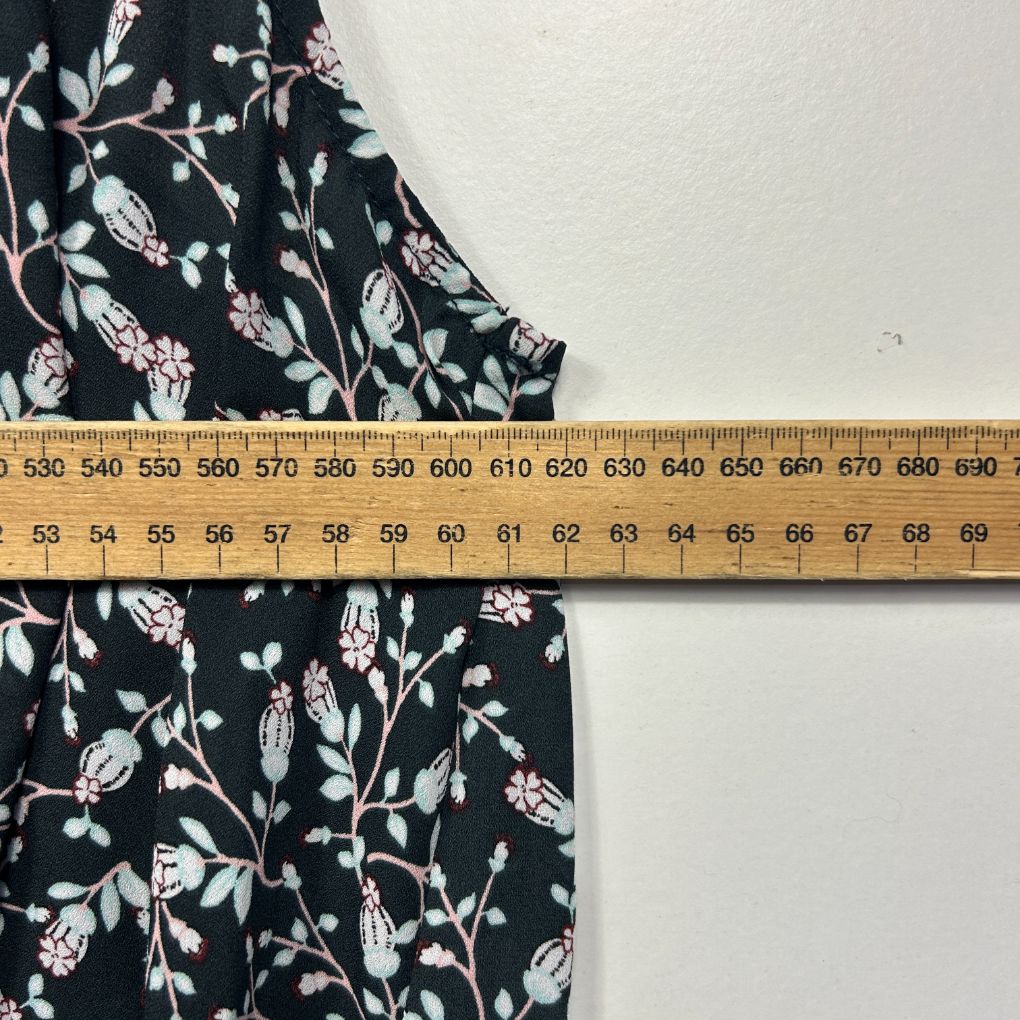 Black floral print dress detail view with measuring tape