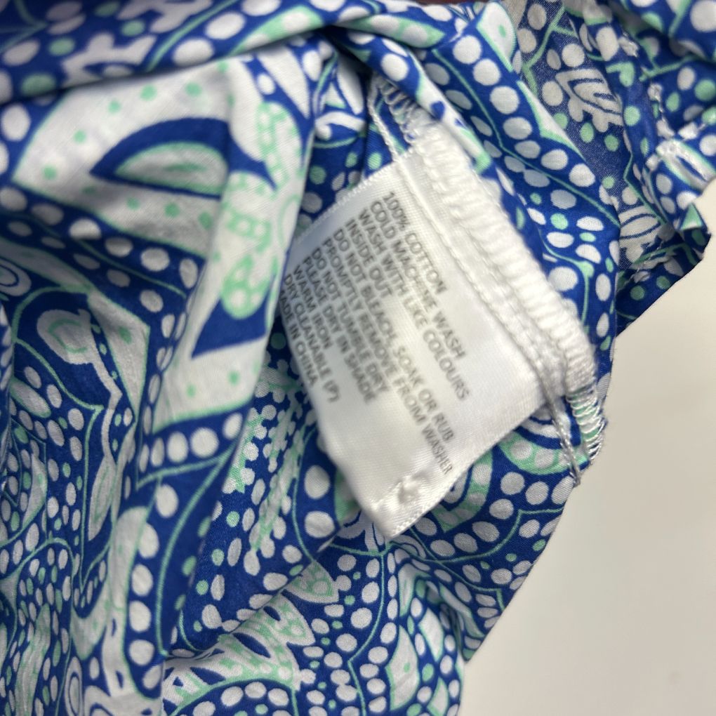 Blue and white patterned fabric with care label detail view