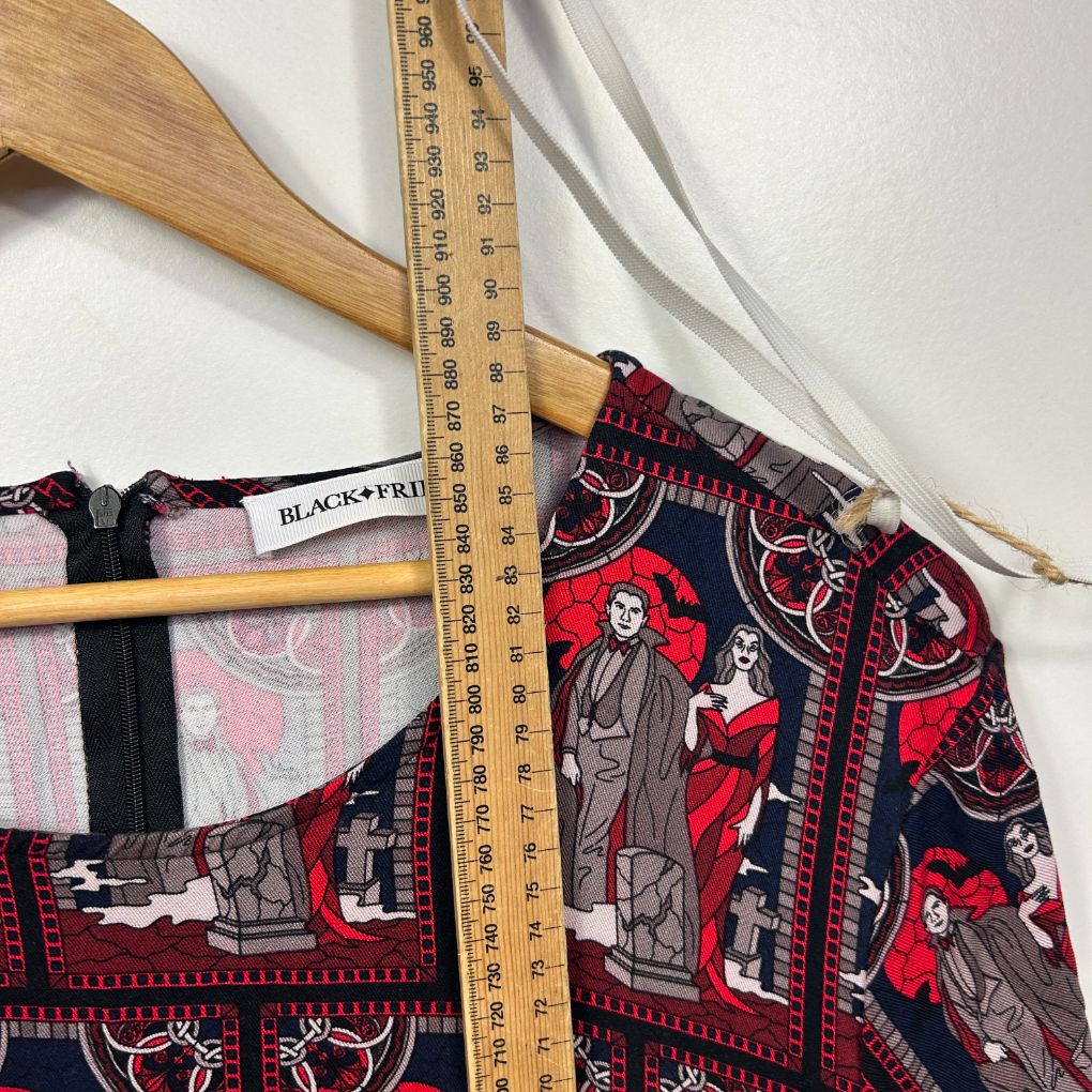 Red and black graphic print dress detail view with measuring tape