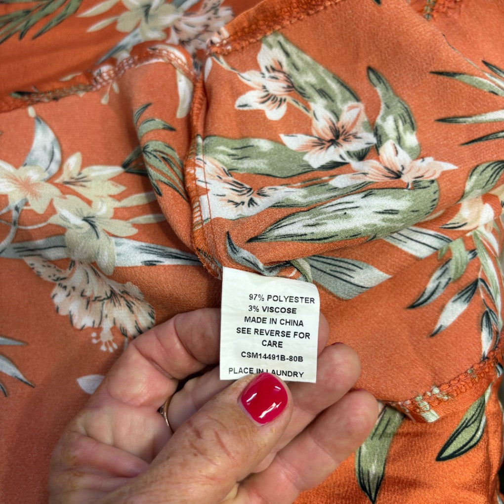 Orange floral fabric detail view with care label