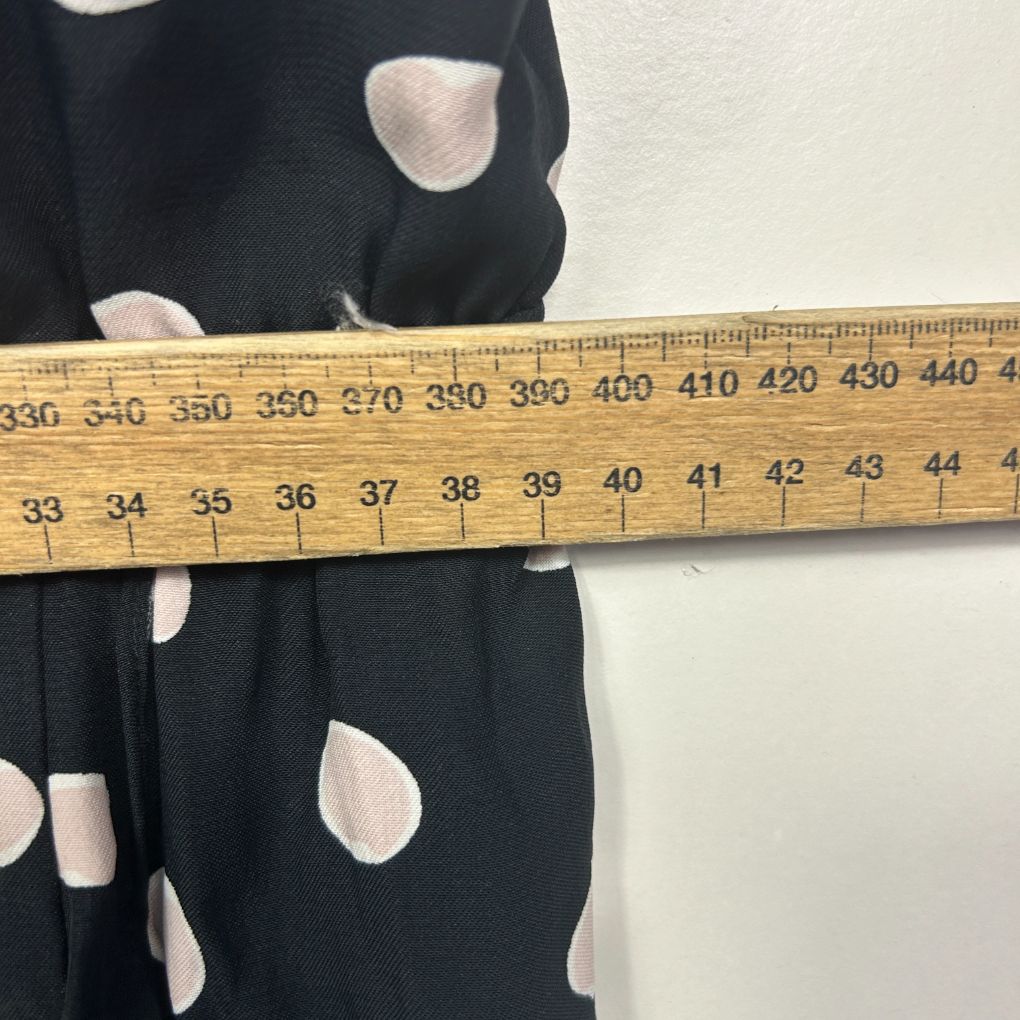 Black and white polka dot fabric with measuring tape detail view