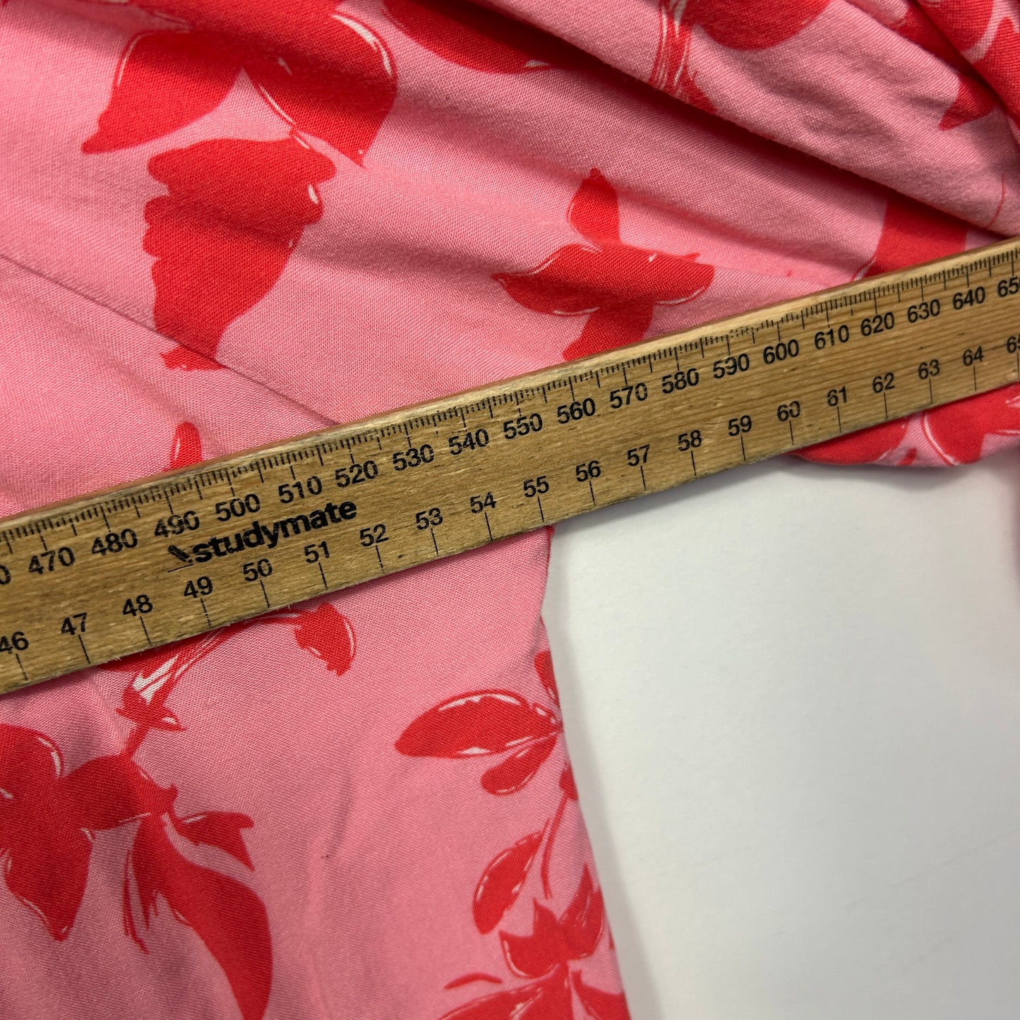 Pink floral fabric with measuring tape detail view