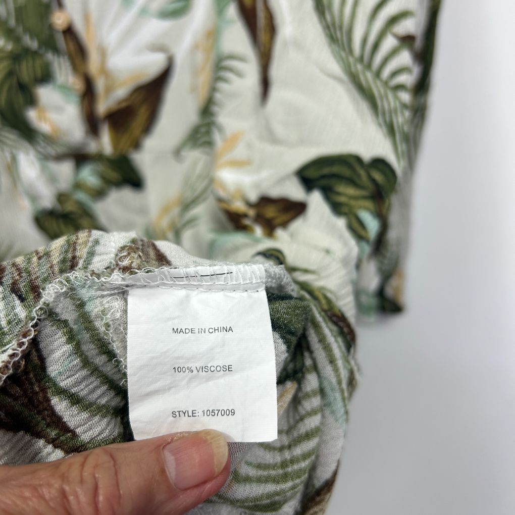 Green and white floral viscose garment label detail view