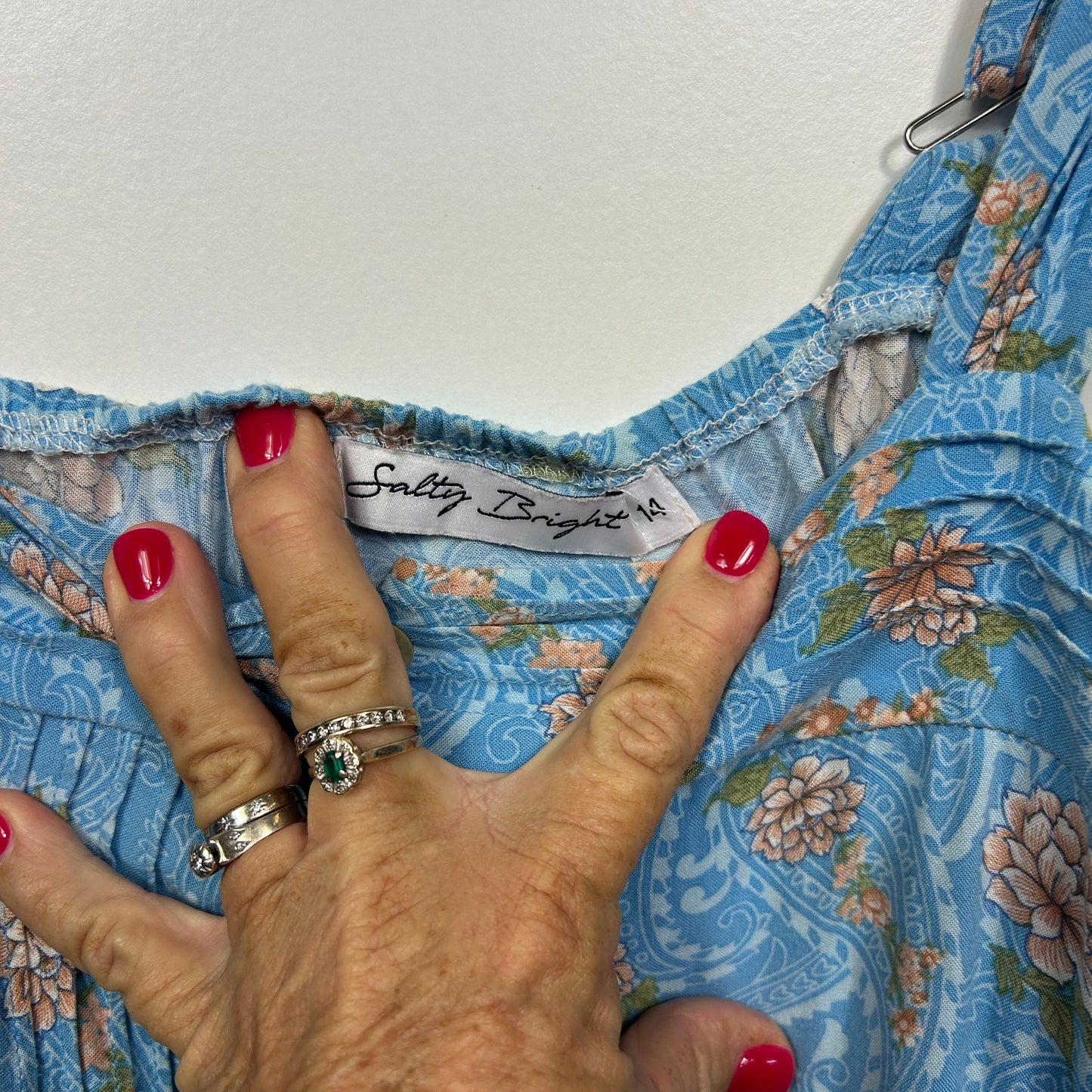 Blue floral dress detail view with hand