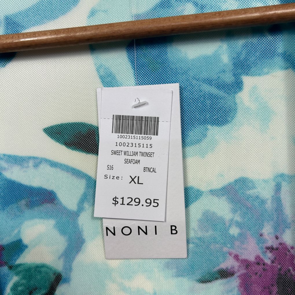 Blue floral garment with price tag and wooden hanger detail view
