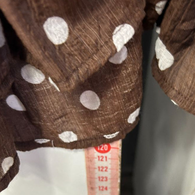 Brown polka dot cardigan detail view with measuring tape