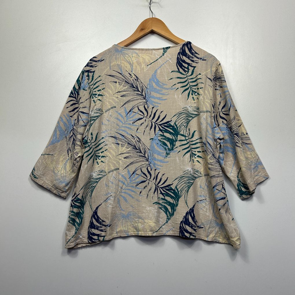 Beige tunic top with blue and navy floral leaf print front view