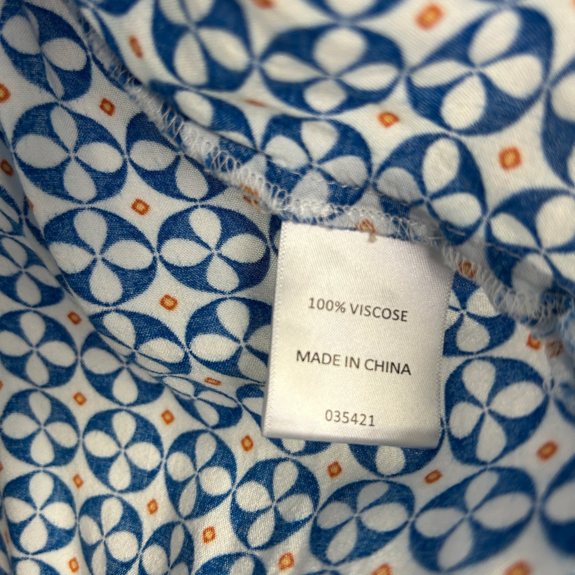 Blue and white geometric patterned fabric label detail view