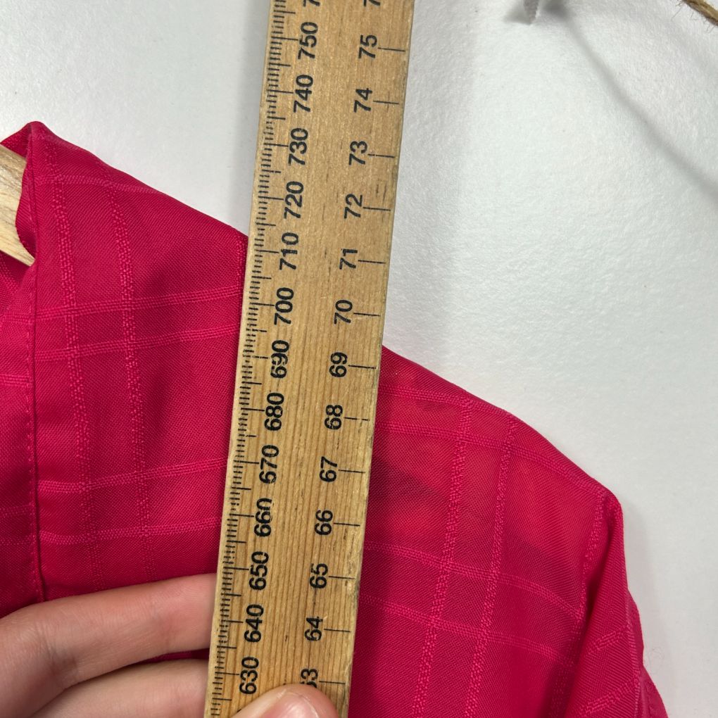 Red fabric being measured with ruler detail view