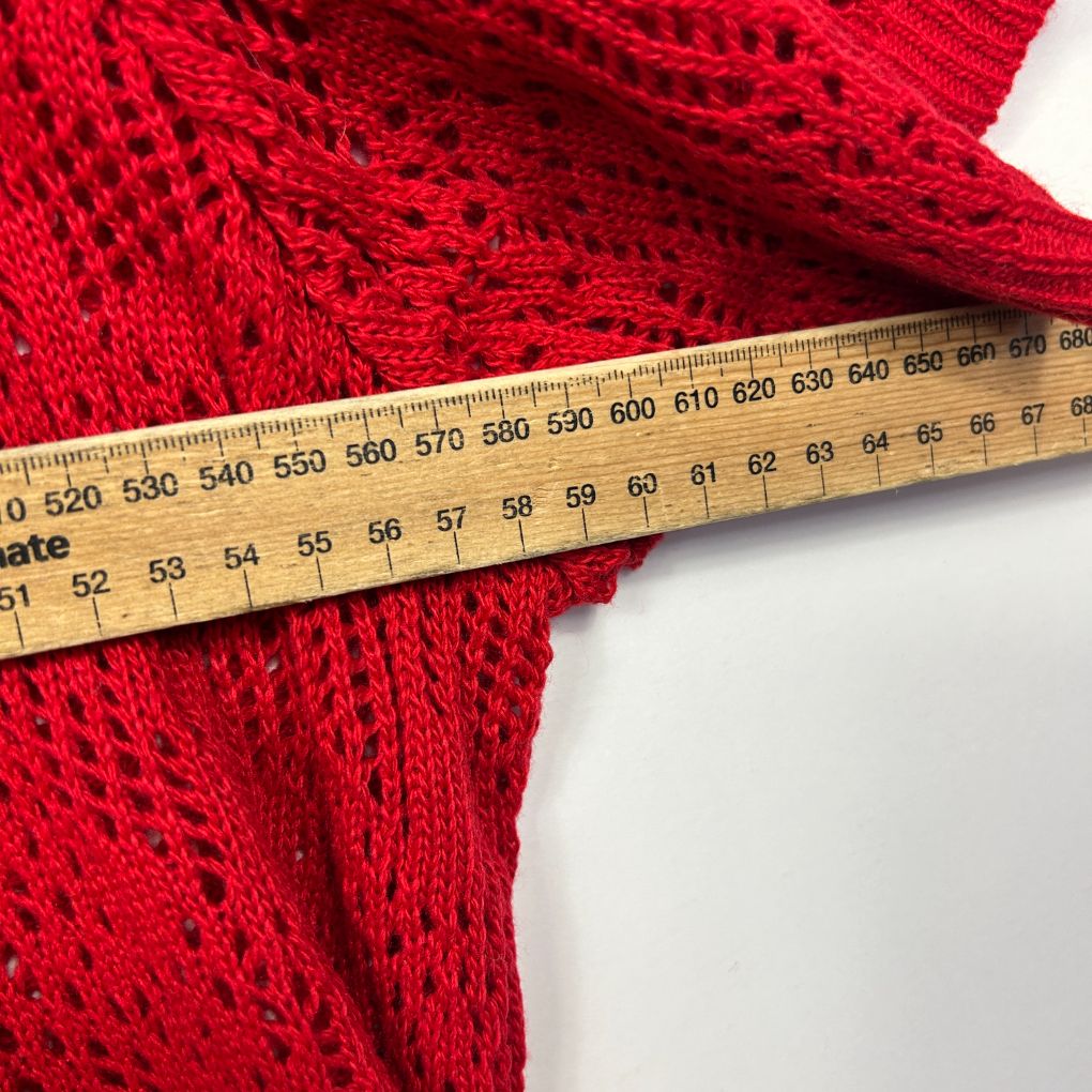 Red knit fabric detail view with measuring tape
