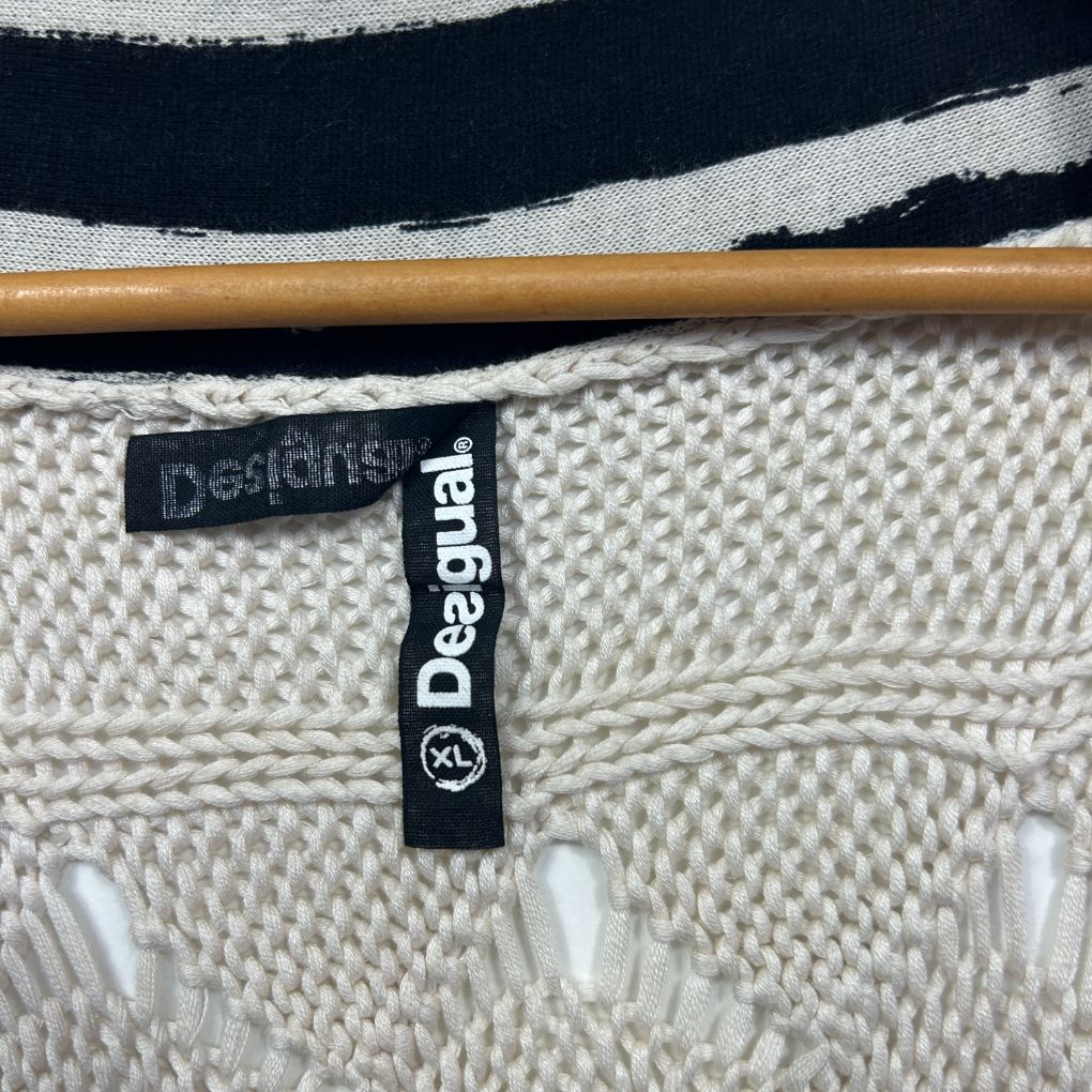 Cream knit sweater label detail view