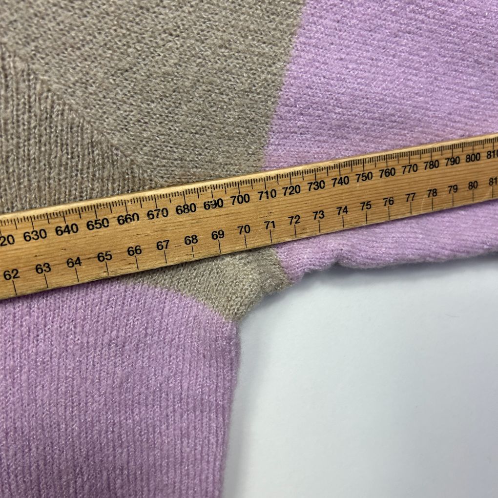 Purple and sage green knit fabric detail view with measuring tape