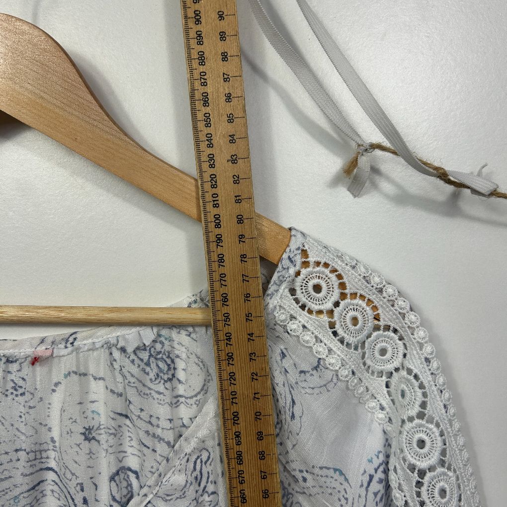 White lace top detail view with measuring tape