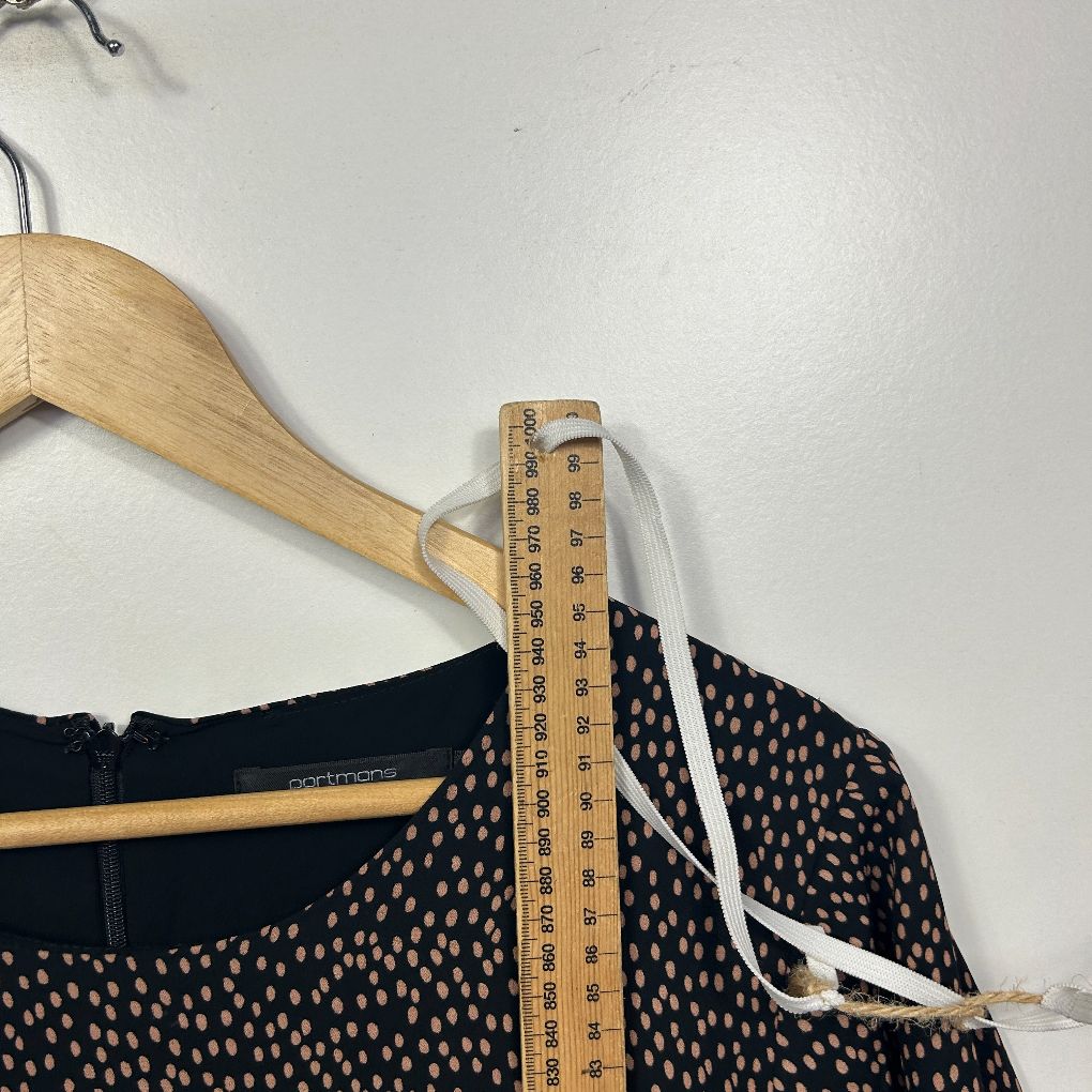 Navy polka dot blouse front view with measuring tape