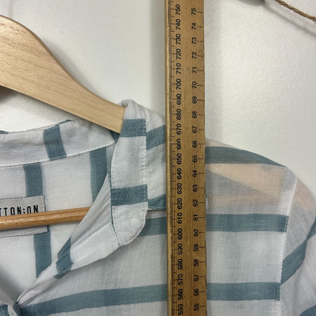 White and teal checked shirt detail view with measuring tape