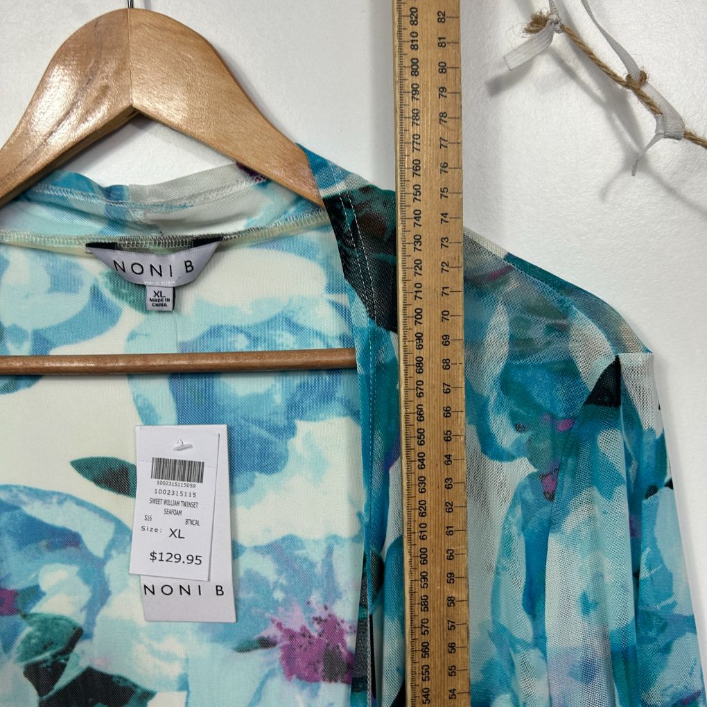 Blue floral top front view on wooden hanger with measuring tape