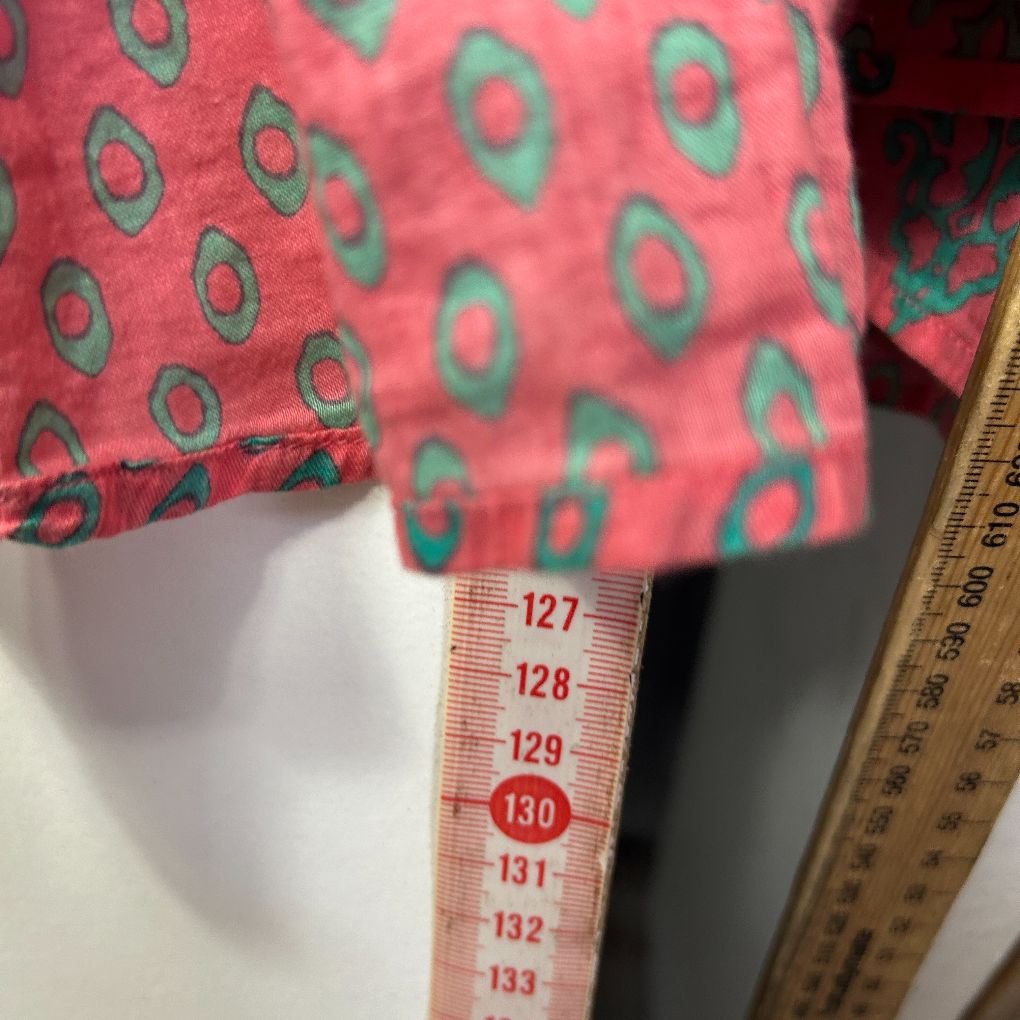 Pink long sleeve top with green circular pattern detail view