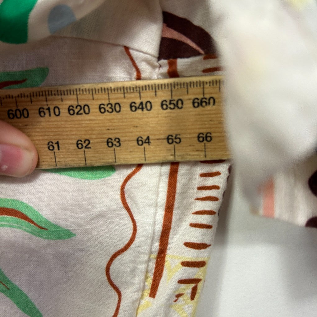 Cream garment detail view with measuring tape