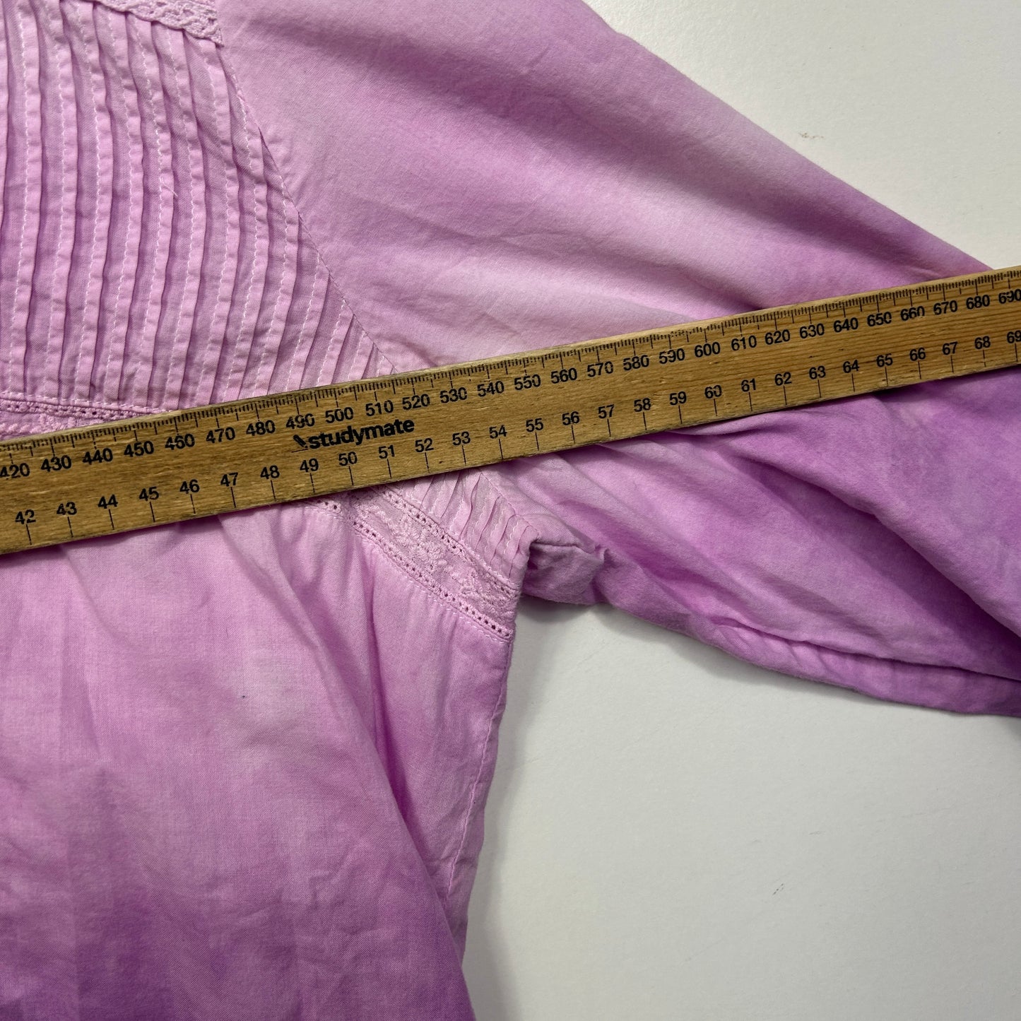 Purple long sleeve top detail view with measuring tape