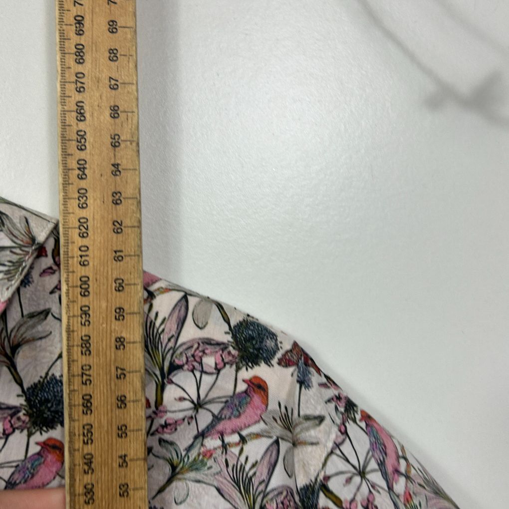 Cream floral dress detail view with measuring tape