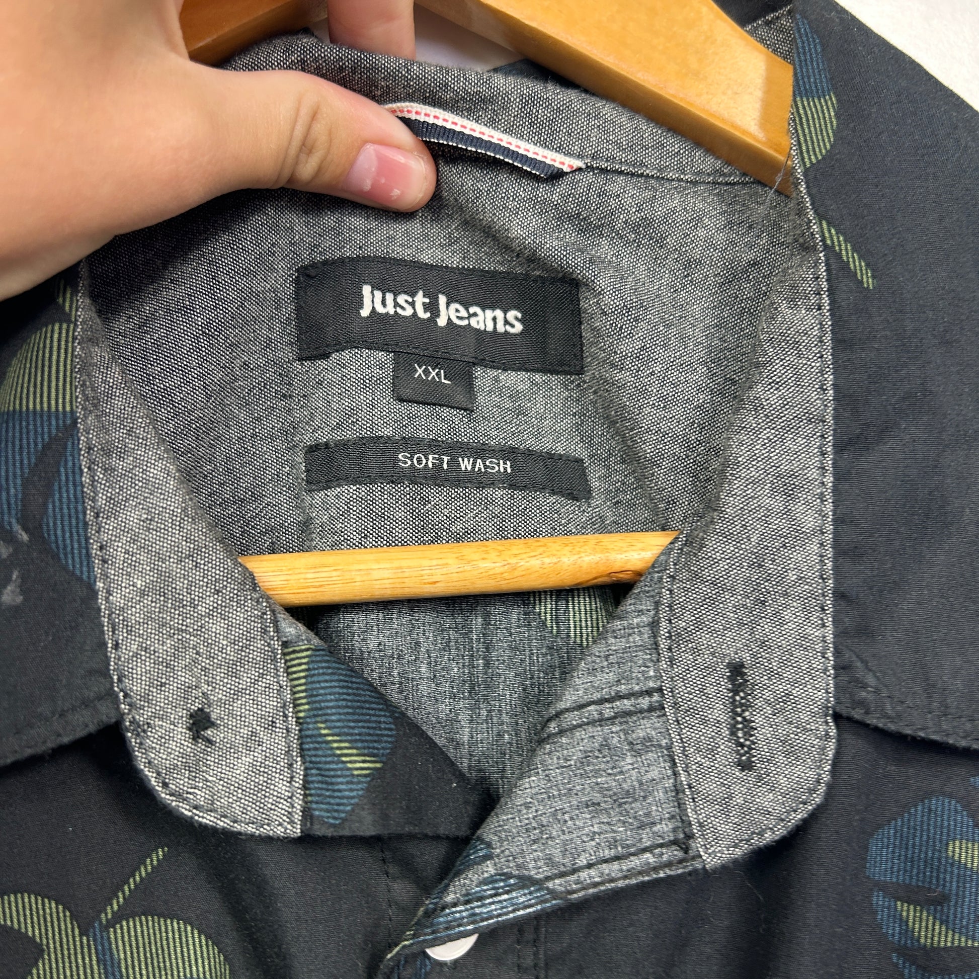 Grey and black shirt front detail view showing label