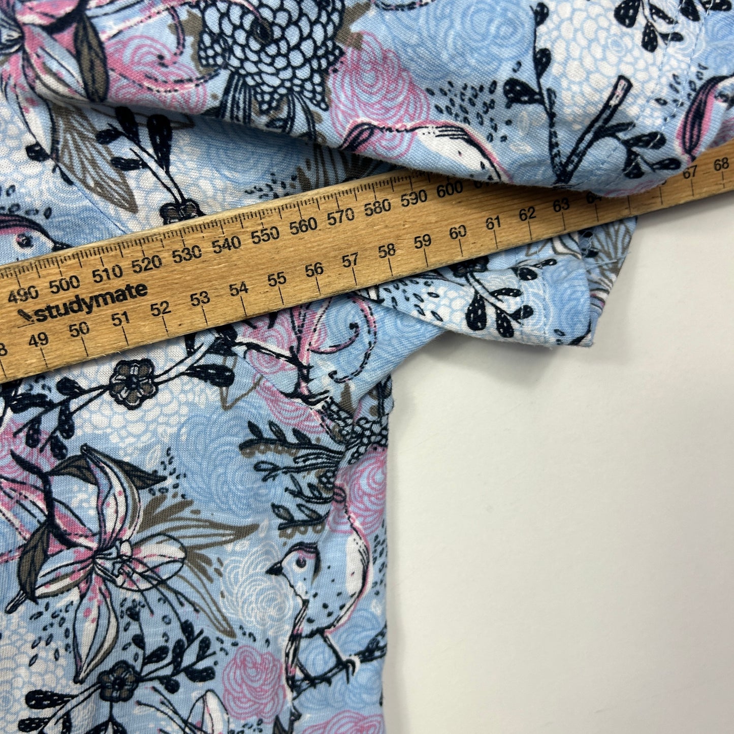Blue floral fabric detail view with measuring tape