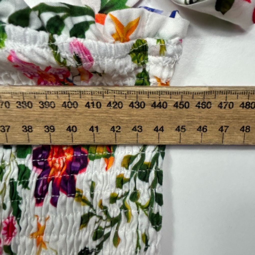 White smocked fabric with colorful floral pattern detail view