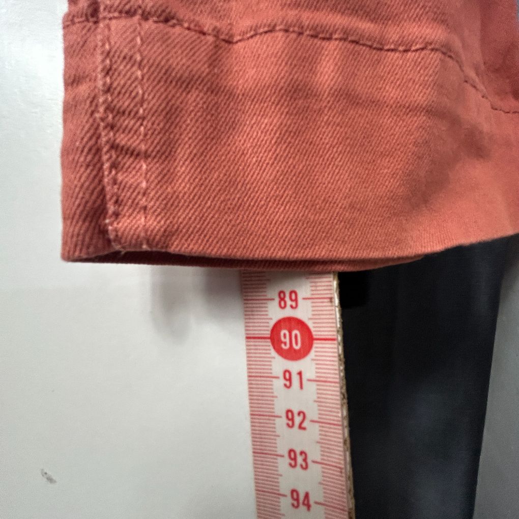 Terracotta corduroy shirt detail view with measurement tape