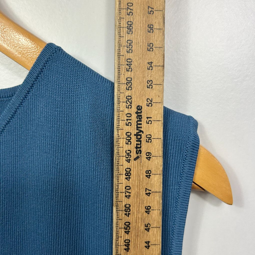 Blue ribbed knit sweater detail view with measuring tape
