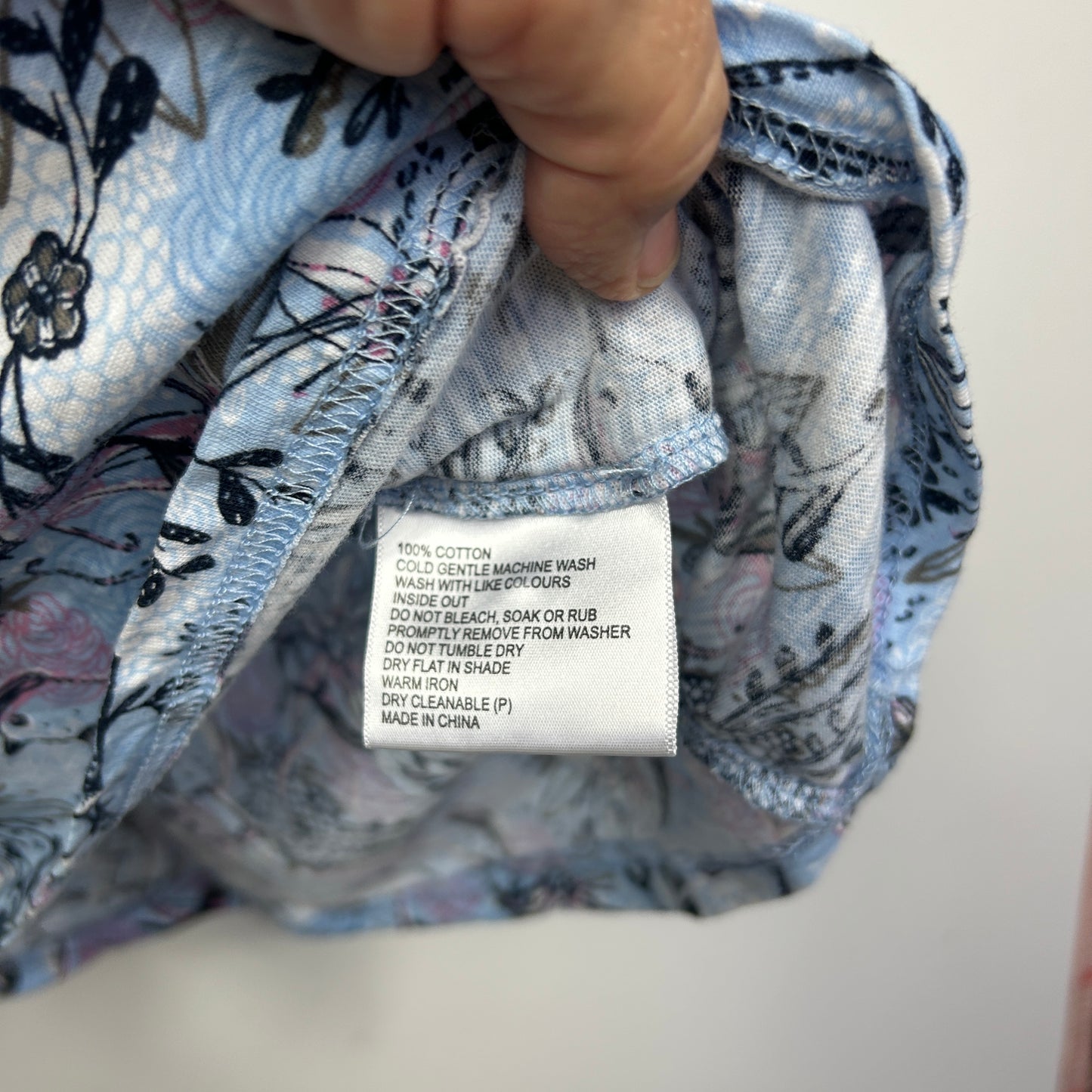 Blue floral jacket detail view showing care label