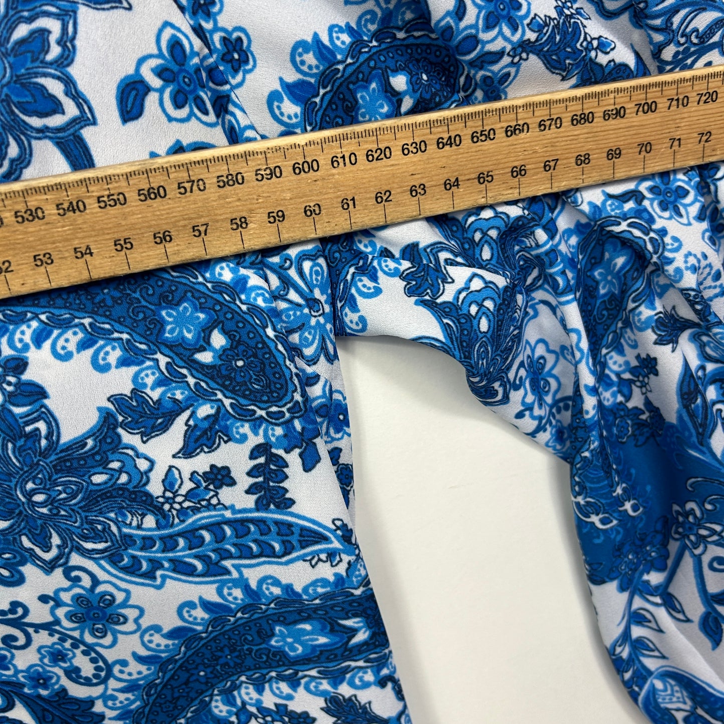 Blue and white floral fabric detail view with measuring tape