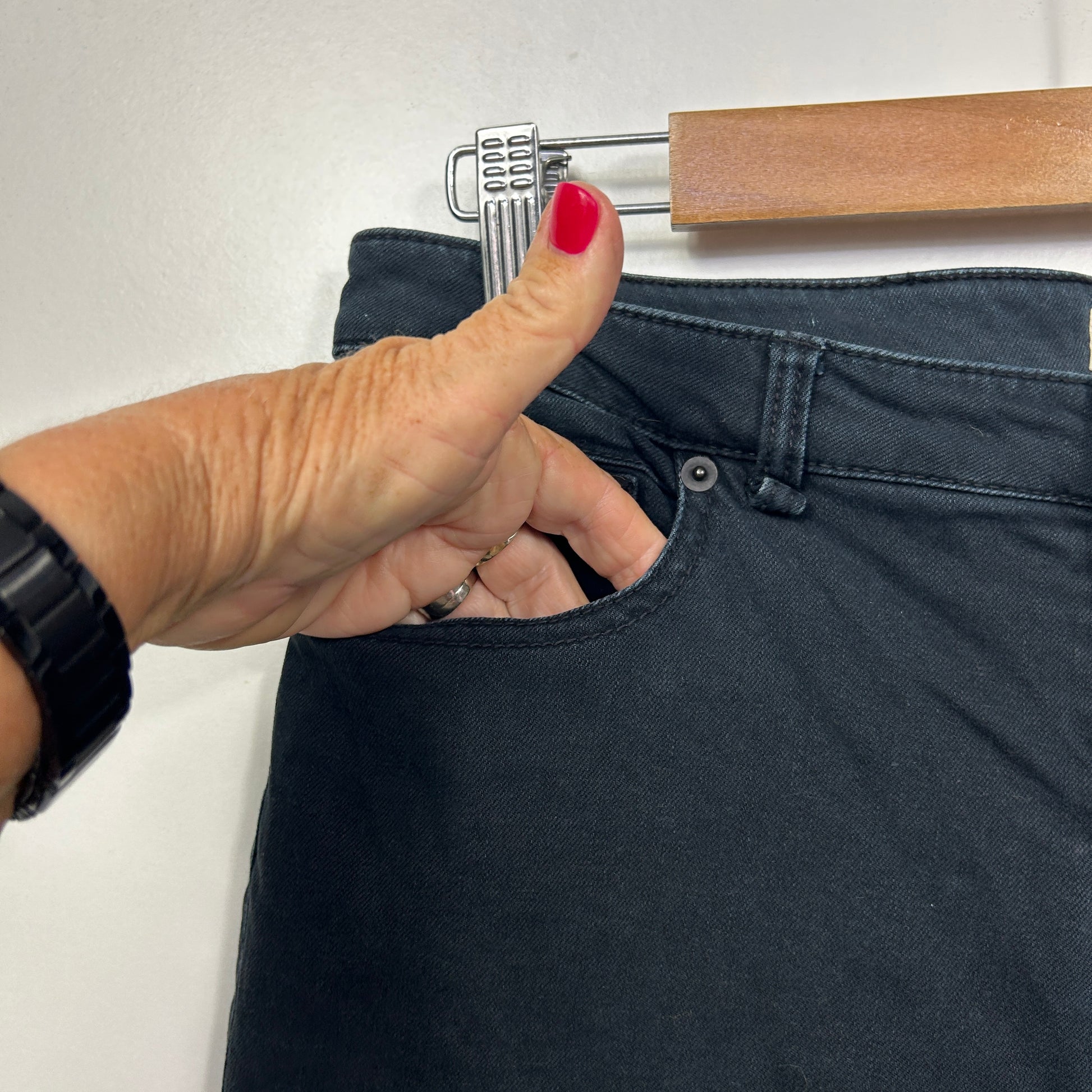 Black jeans detail view showing waistband and belt