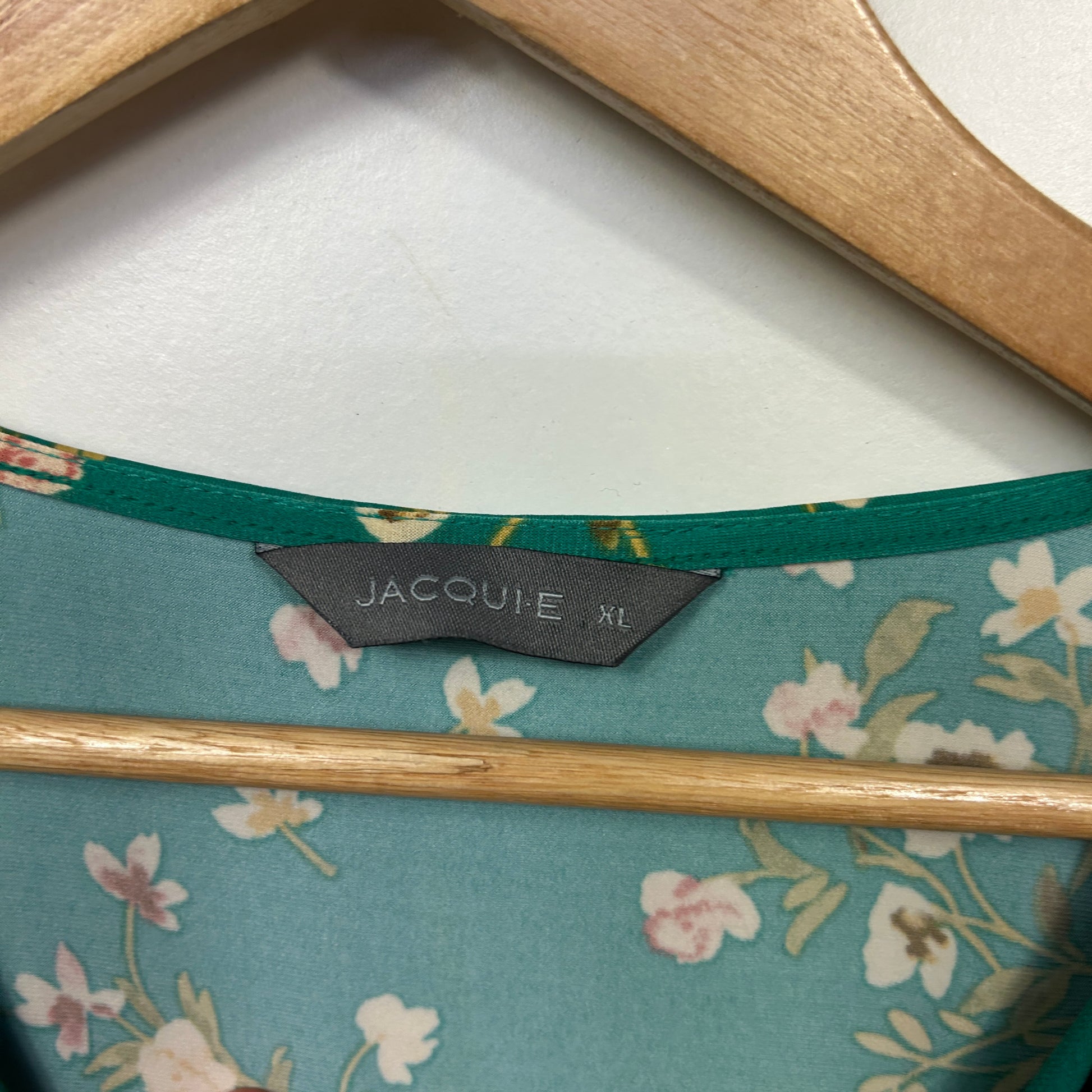 Teal floral top detail view showing label