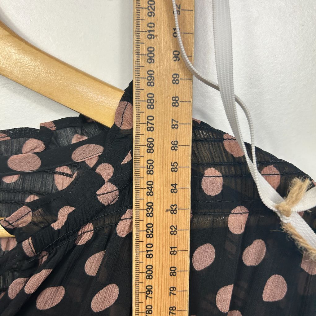 Black dress with terracotta polka dot pattern detail view