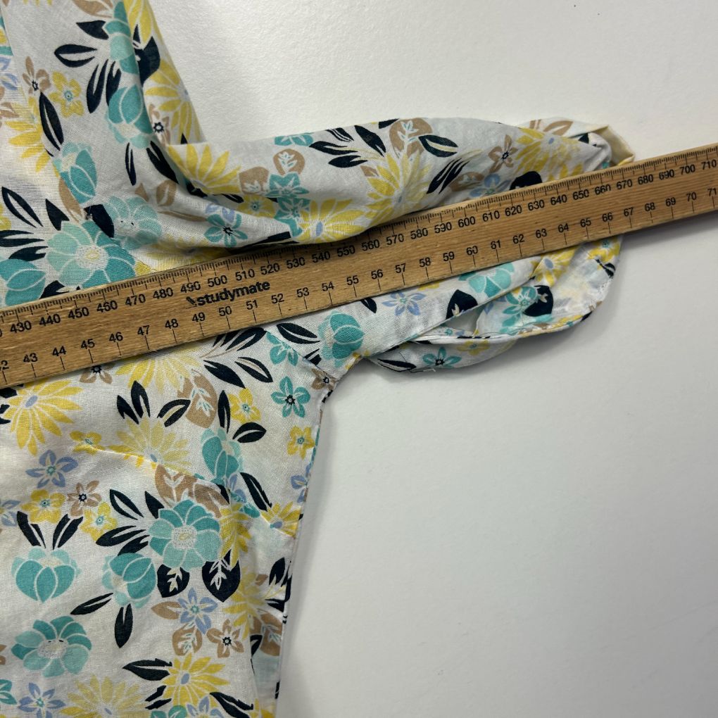 Floral print blouse detail view with measuring tape