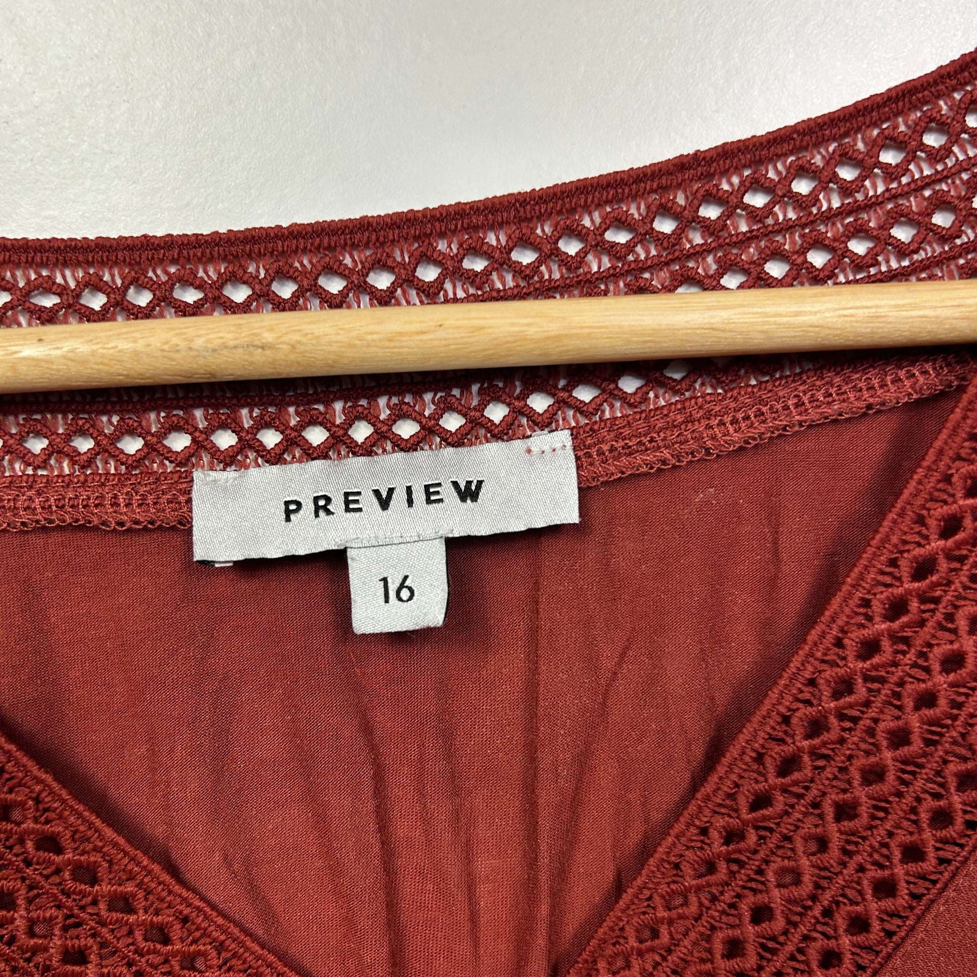 Burgundy lace top detail view showing label