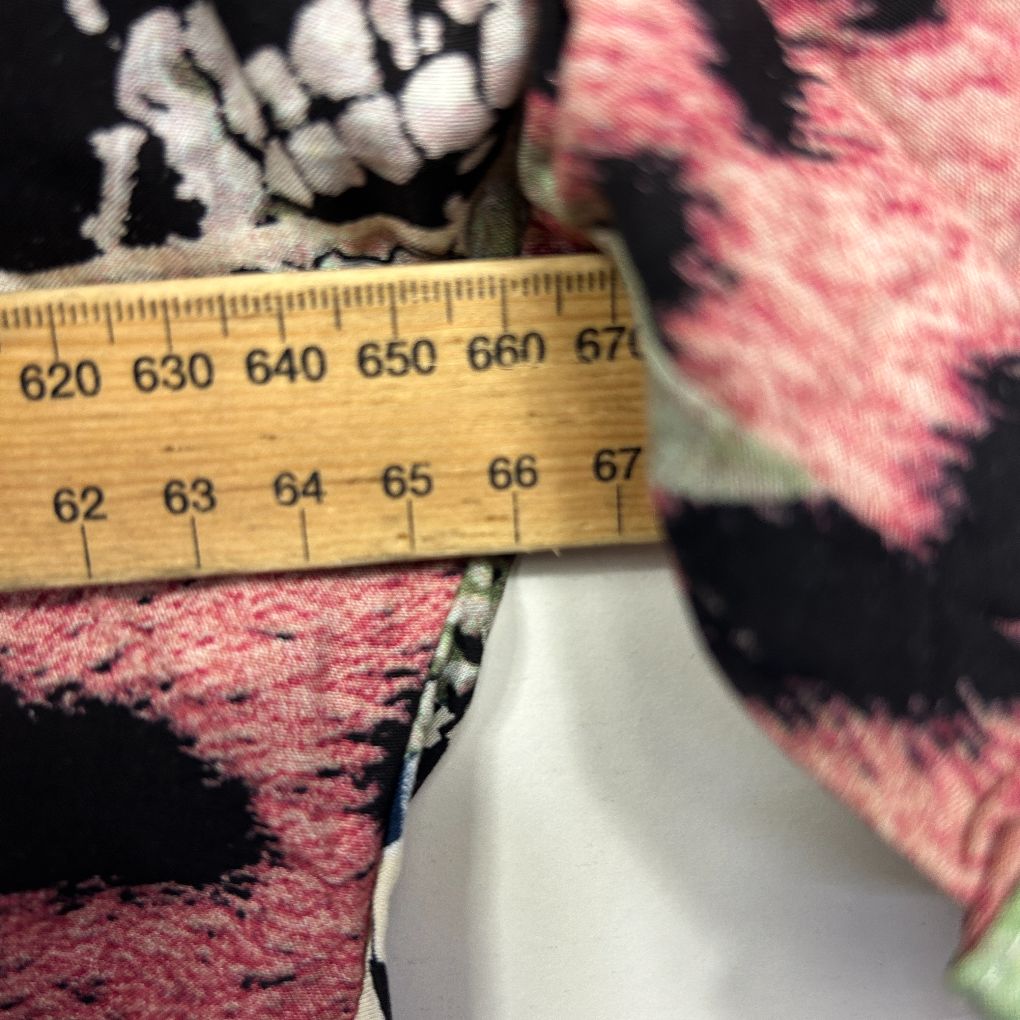 Pink and black patterned fabric detail view with measuring tape