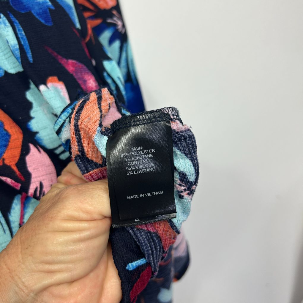 Colorful floral patterned garment detail view showing label