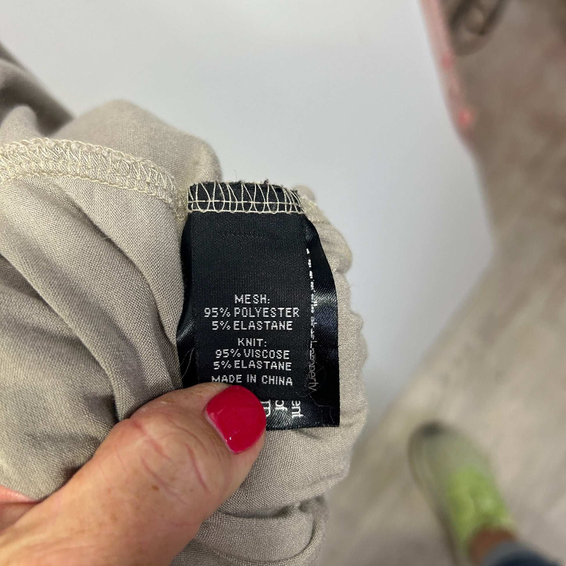 Beige knit detail view showing black care label