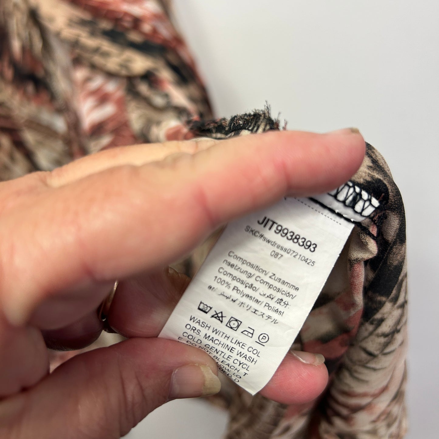 Beige and brown patterned garment label detail view