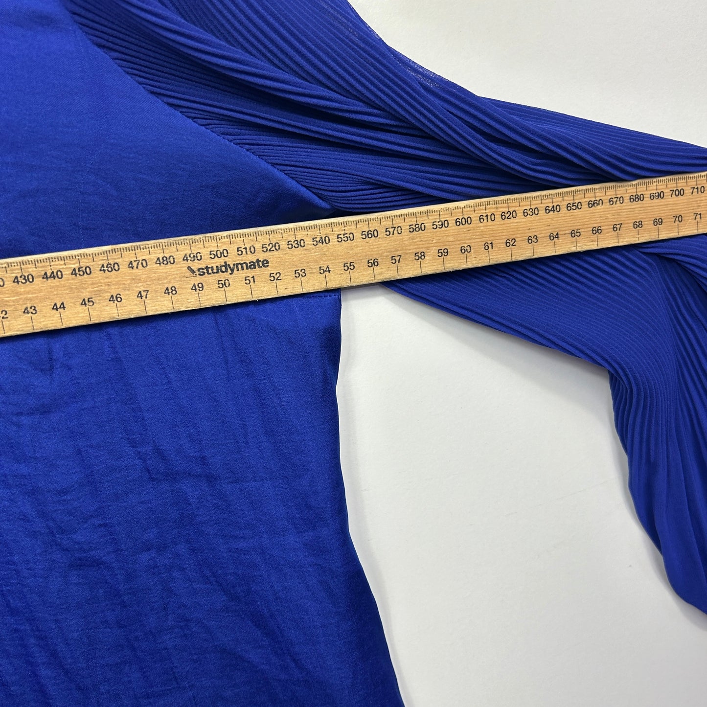 Blue pleated fabric detail view with measuring tape