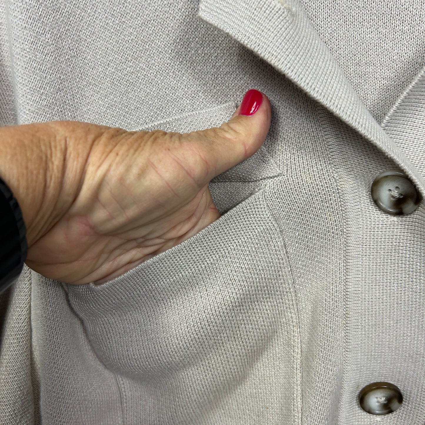 Cream cardigan detail view showing pocket and buttons